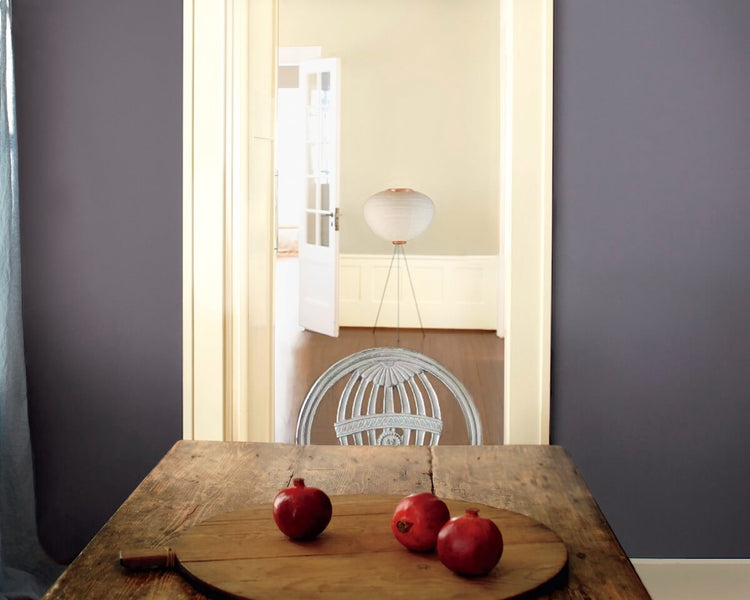 Rustic plank table with gray-blue wall and pomegranates